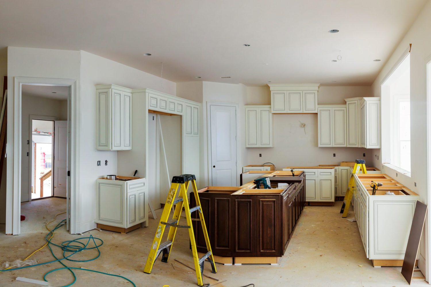 Installation of kitchen. Custom kitchen cabinets in various stages of installation base for island in center